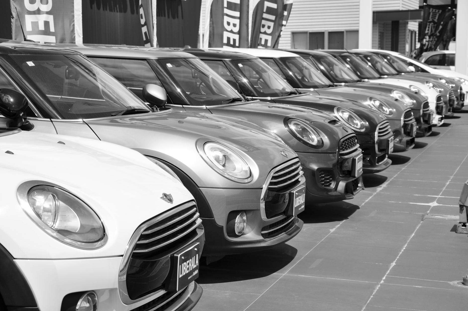 Czarno-białe zdjęcie rzędu zaparkowanych miejskich aut w salonie