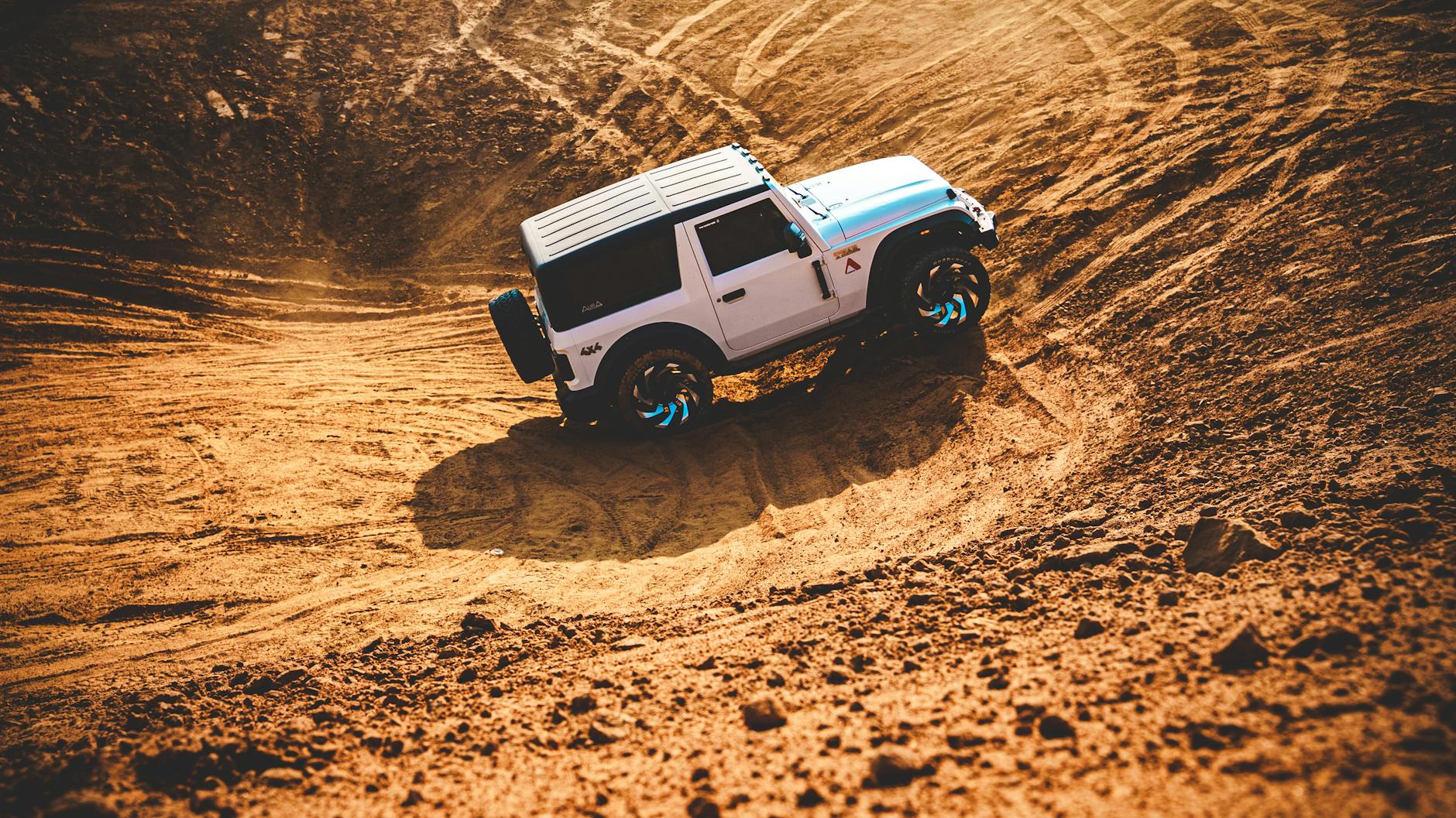 Jeep terenowy jedzie dynamicznie po piaszczystych wydmach