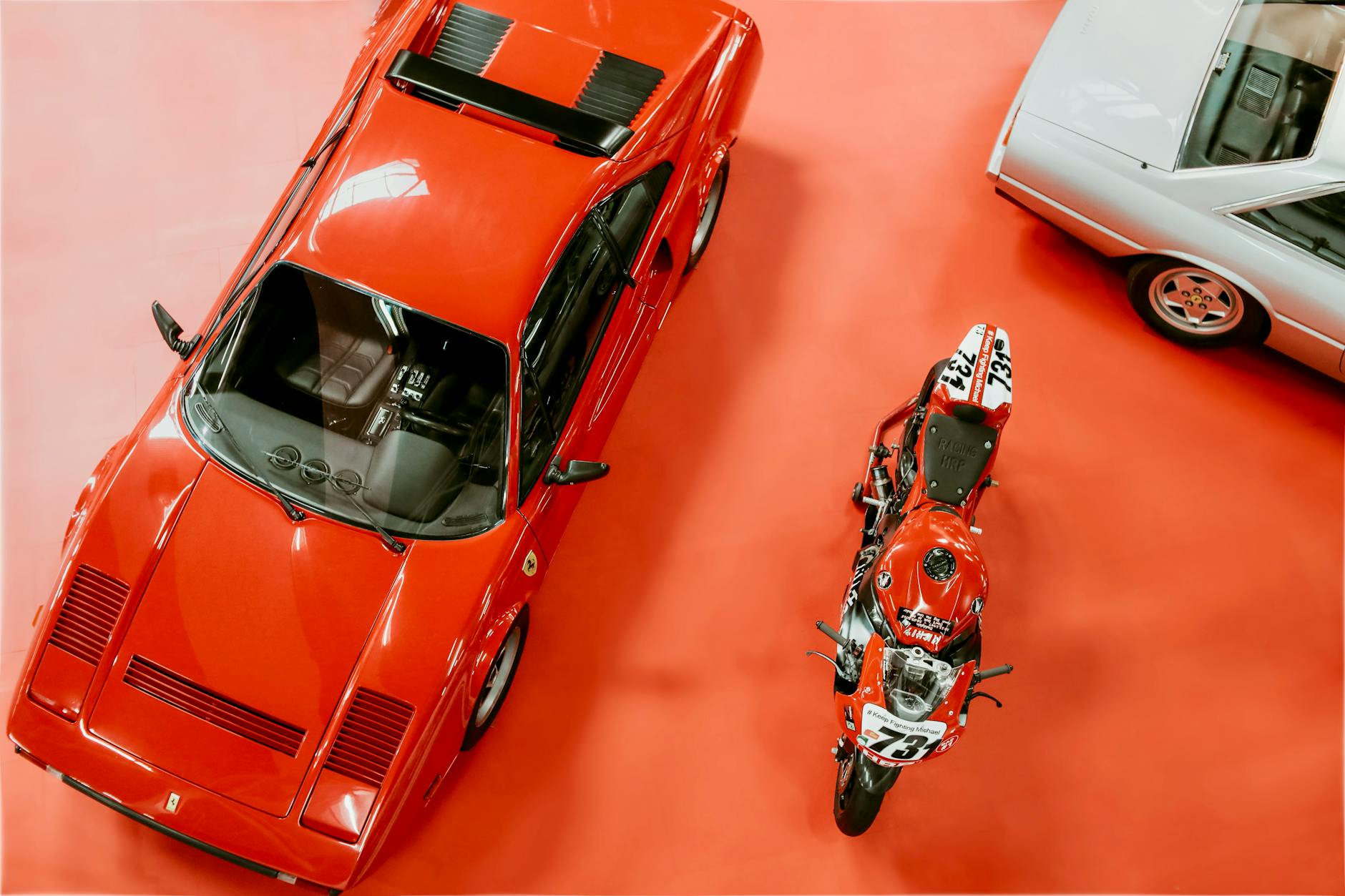 Klasyczny czerwony Ferrari i motocykl oglądane z góry na wystawie