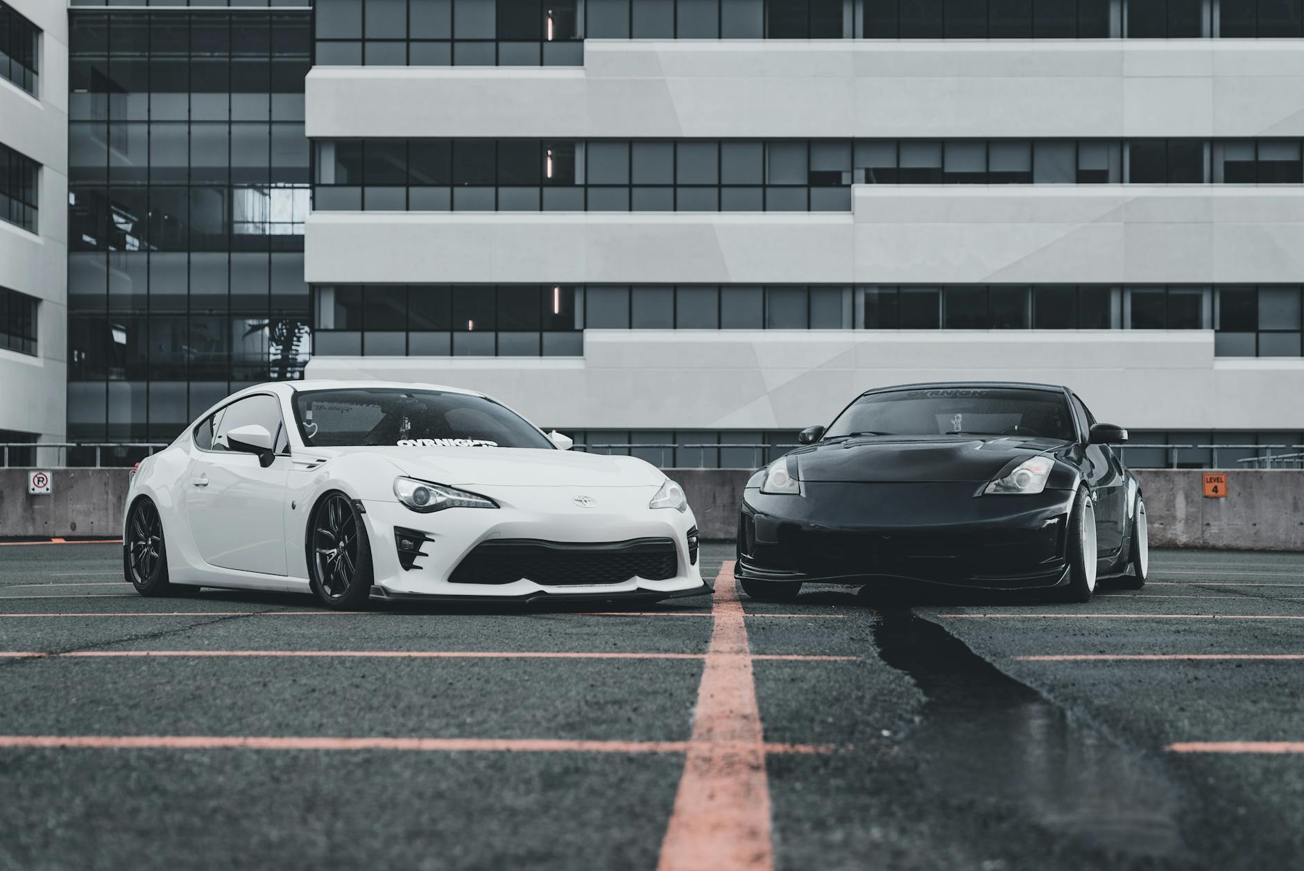 Biała i czarna sportowa Toyota zaparkowane przy ulicy w mieście