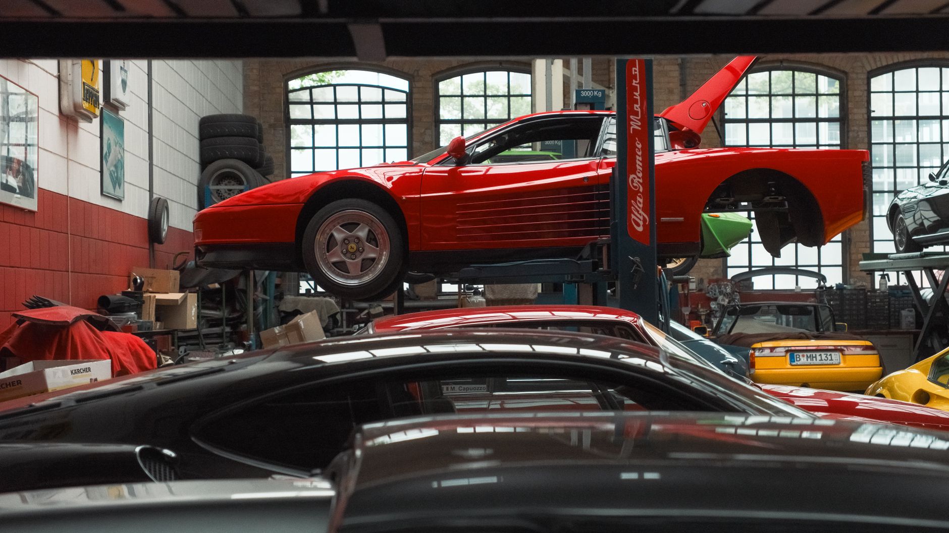 Czerwone Ferrari na podnośniku w warsztacie samochodowym