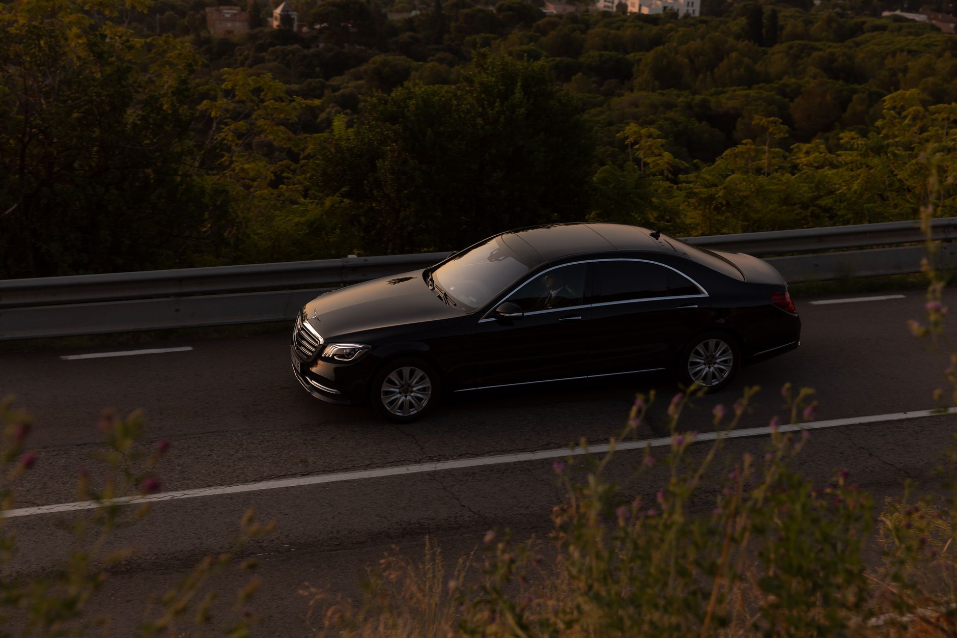 Czarna Skoda Superb jedzie leśną drogą za dnia